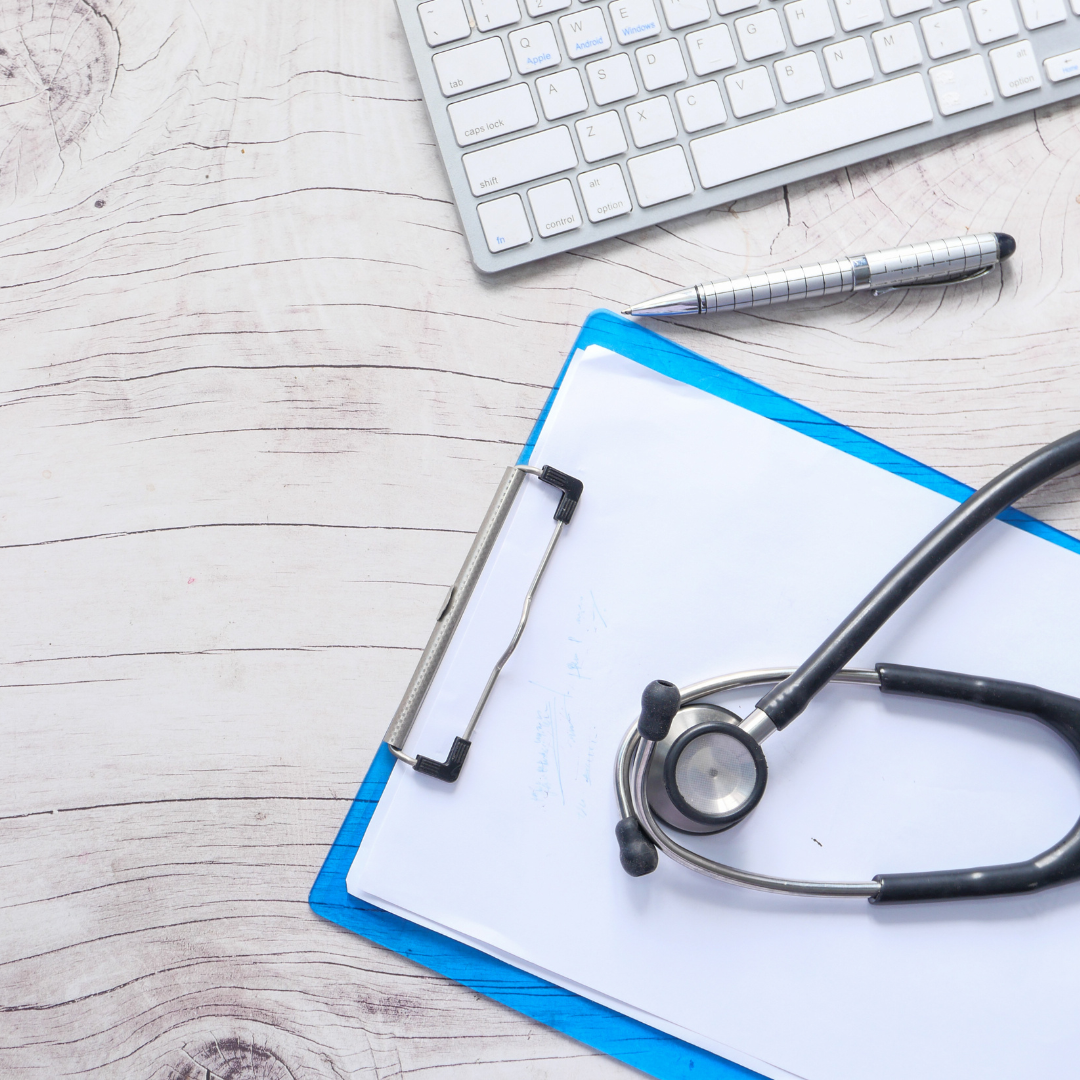 Flat lay of clipboard, keyboard and stethoscope